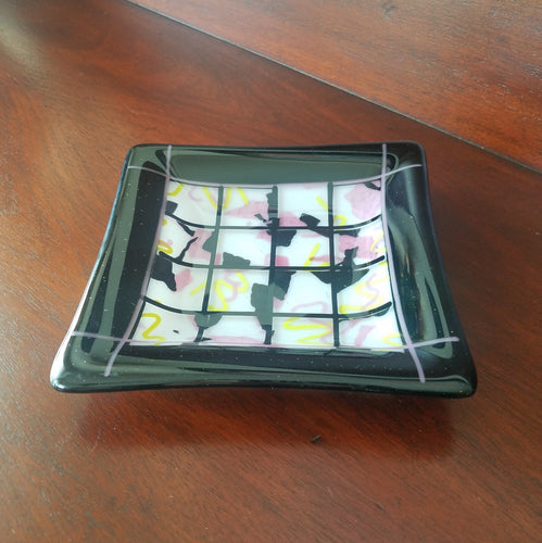 This is a beautiful hand-crafted decorative glass plate with a confetti design of pink, yellow, black and white. Dimensions: 5-3/4