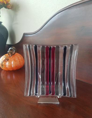 This decorative plate has dark stripes molded with clear glass.